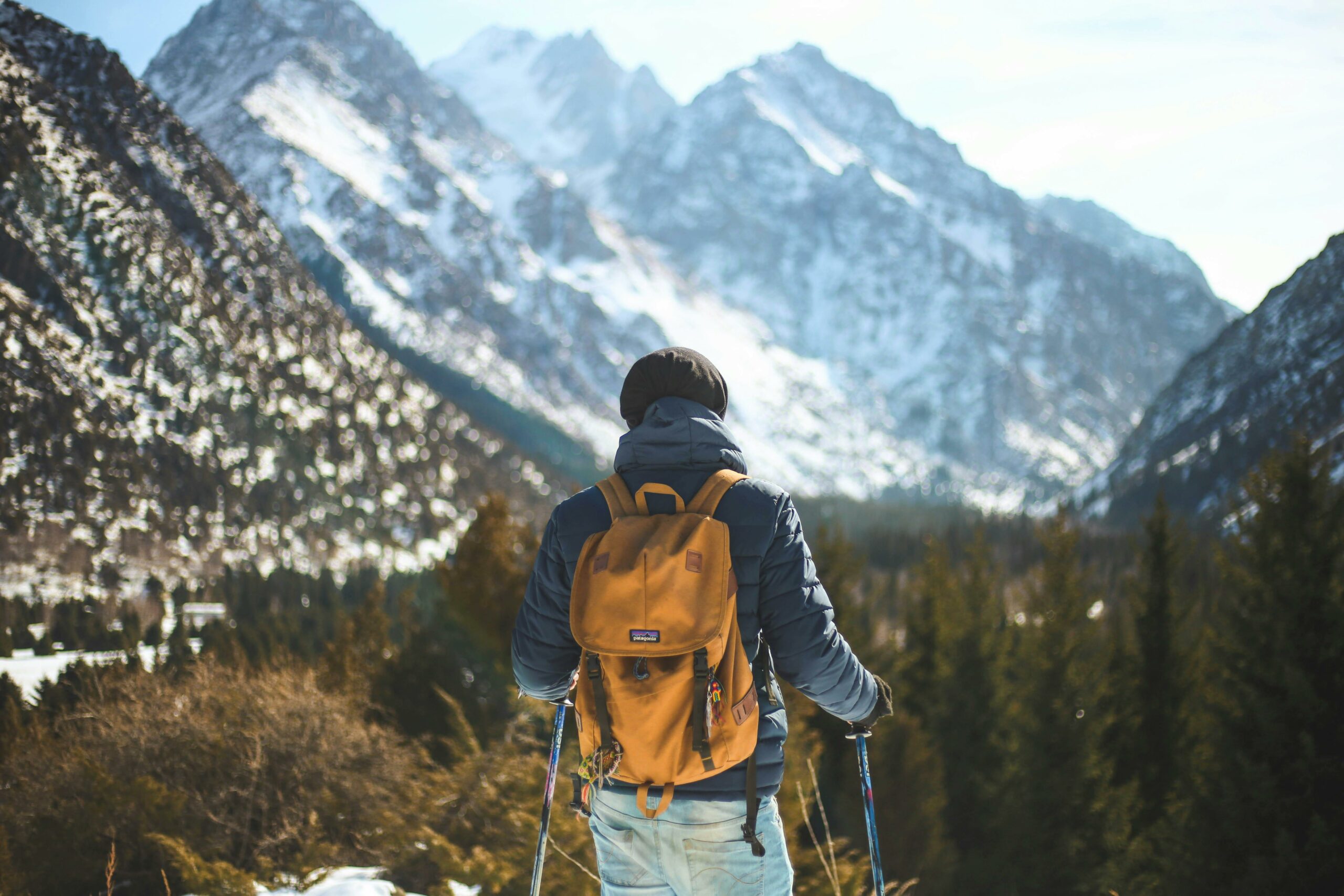 Randonneur en balade hivernale dans le Queyras avec sac à dos et montagnes enneigées