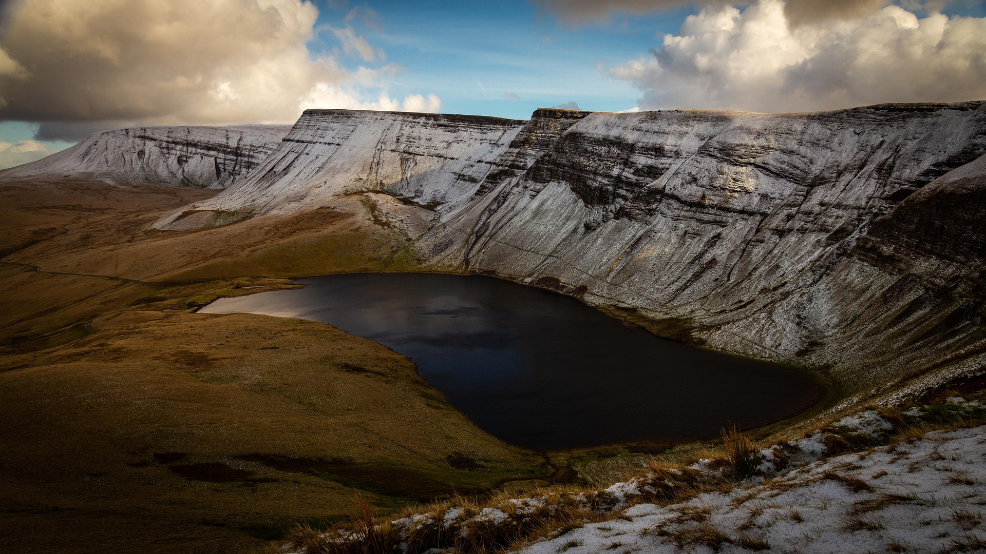 Lac de montagne entouré de falaises rocheuses dans le Parc naturel du Queyras