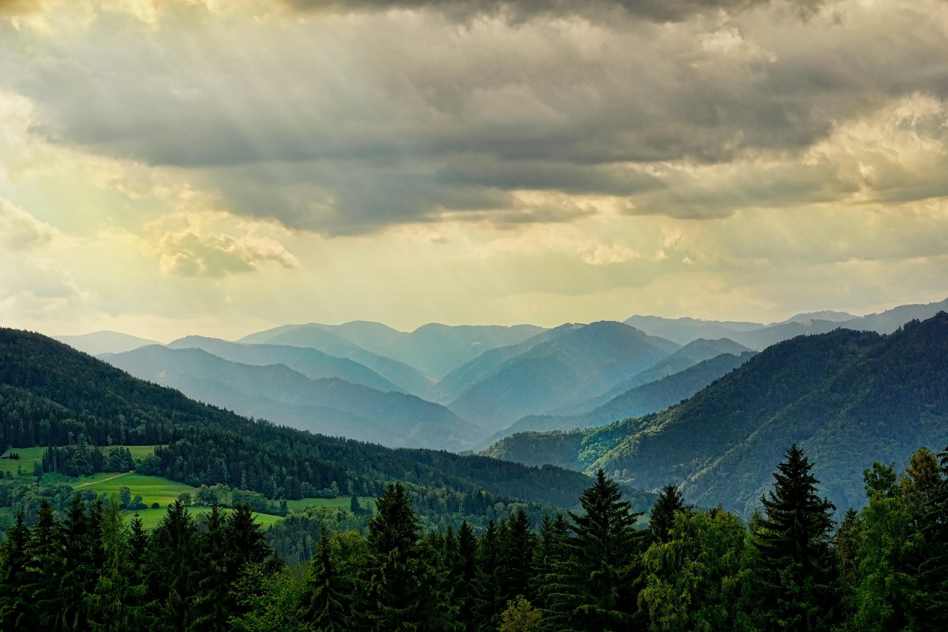 Chaîne de montagnes verdoyantes sous un ciel nuageux